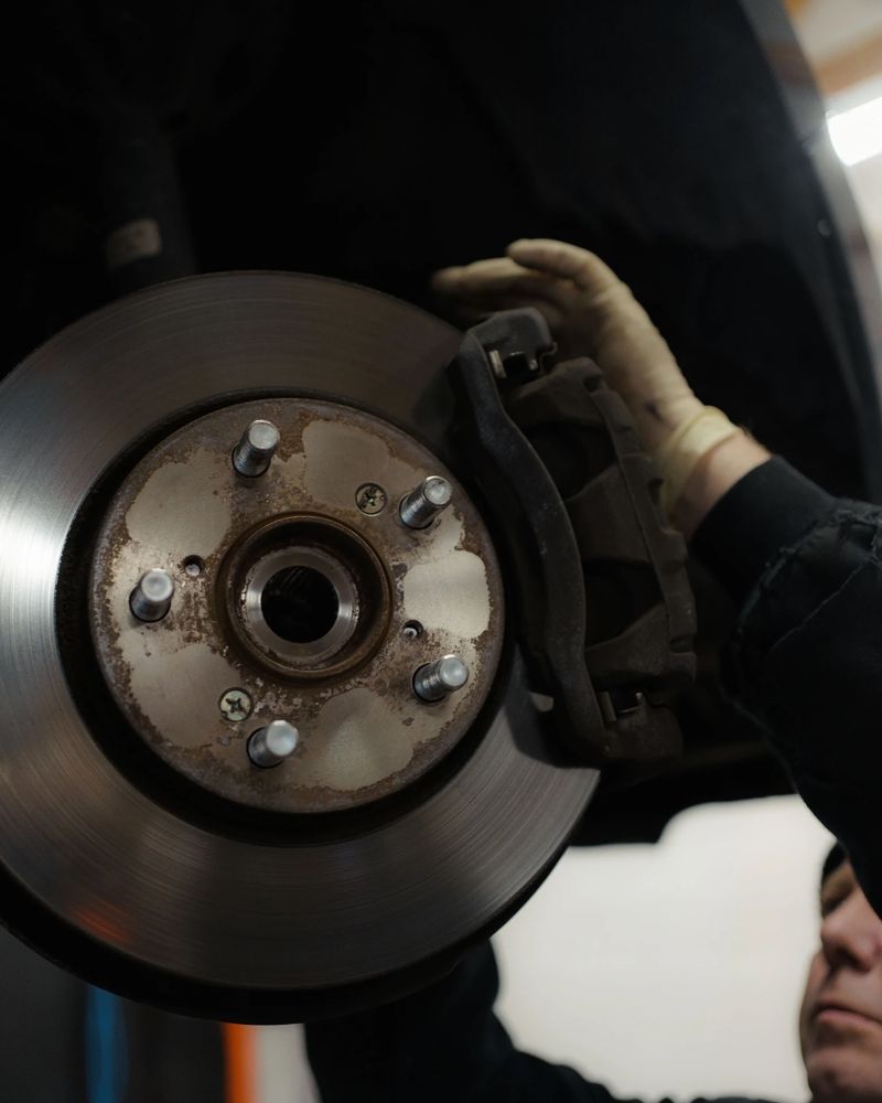 New brake rotor and caliper on a raised car