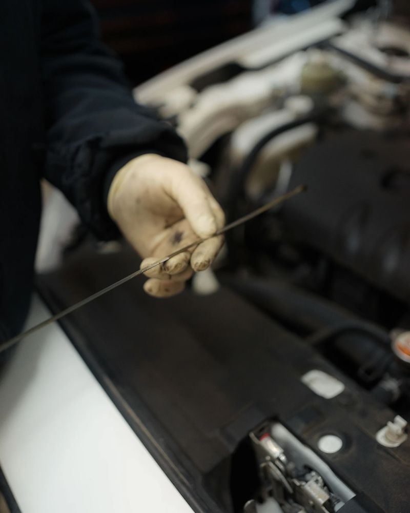 Mechanic checking engine oil with the dipstick